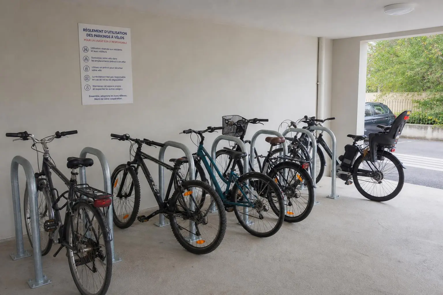 Râteliers vélo au sol dans un local collectif d'immeuble