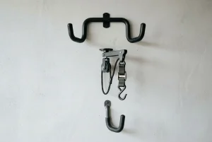 Crochet pour suspendre vélo mural avec support métallique et sangles, montrant un crochet supérieur et un autre en bas pour ranger le cadre ou la roue. Crochet pour suspendre vélo.